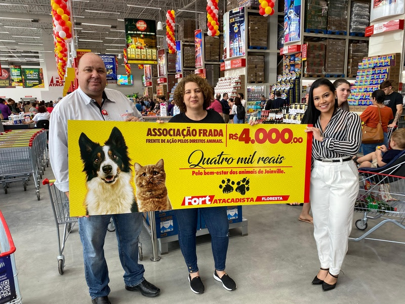 Gilson Alonso, gerente da loja, e Dayanna Souza, analista de marketing do Fort Atacadista, entregam cheque para Liliane Lovato (centro), presidente da Associação FRADA - Foto: Paes e Lima Comunicação